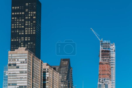 Gebäude im Bau mit Kran an einem Gebäude in New York City vor blauem Himmel. Hochwertiges Foto