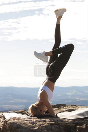 Photo for Young attractive woman doing yoga and sport on the top of the mountains,Yoga outdoor, legs up, mountains view, sport body, fitness group.meditation, relaxing, deep breath, healthy eating, balance body, fitness training, landscape view, Swiss alps - Royalty Free Image