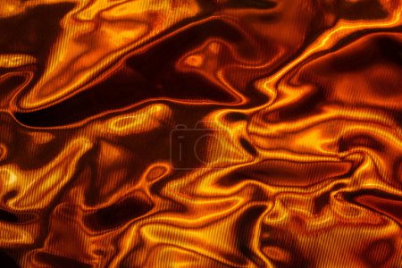 Photo for Crumpled foil with light playing on its surface. Visual effect. Abstract orange-black background - Royalty Free Image