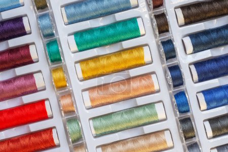 Foto de Arco iris disposición de los hilos de coser en un recipiente de plástico - Imagen libre de derechos