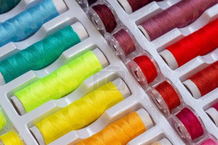 Foto de Hilos multicolores y bobinas de plástico para máquinas de coser - Imagen libre de derechos