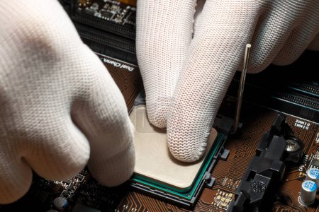 Photo for Man hands in gloves replacing processor on the computer motherboard - Royalty Free Image