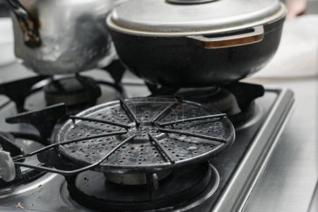 Photo for Detailed view of a Colombian arepa grill placed on a gas stove, ready to prepare the breakfast. - Royalty Free Image