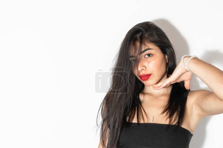 Photo for Beautiful latina woman with brown skin posing on a white background, showing her chin. - Royalty Free Image