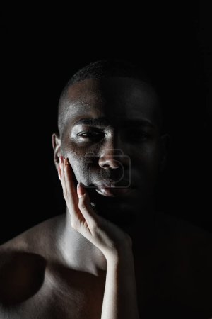 gros plan du visage d'un Afro-Américain avec la main d'une femme blanche sur la joue. Lumière à 90 degrés.