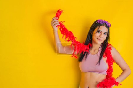 Téléchargez les photos : Latina brunette femme, heureuse avec un fond jaune, avec sa main sur sa taille tout en levant l'autre main. concept de carnaval - en image libre de droit