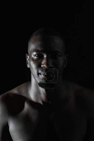 Nahaufnahme des Gesichts eines afroamerikanischen Mannes auf schwarzem Hintergrund mit 90-Grad-Beleuchtung