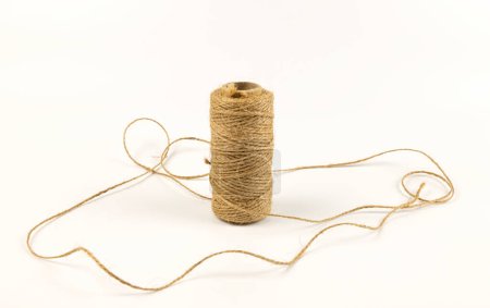 A spool of linen rope on a white background. The concept of textiles and sewing