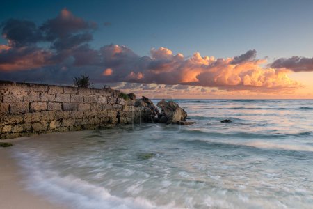 Foto de Puesta de sol en Barbados - nubes rosadas y muro de piedra - Imagen libre de derechos
