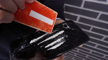 Foto de Cocaína en la superficie del teléfono en las manos de una persona - Imagen libre de derechos