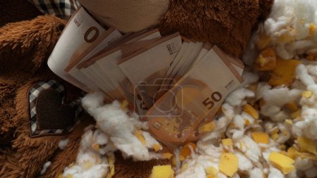 Foto de Oro, joyas y dinero en medio de un juguete de peluche - Imagen libre de derechos