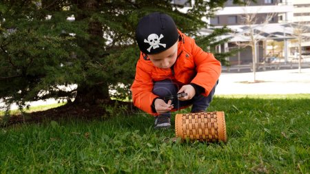 Foto de El chico se dedica al geocaching. el chico encontró un alijo, una caja de madera con monedas - Imagen libre de derechos