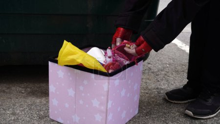 Téléchargez les photos : Une pauvre femme en quête de nourriture dans une benne à ordures trouve des objets en or jetés par quelqu'un - en image libre de droit