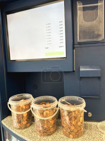 Téléchargez les photos : Pièces de monnaie, petites coupures, dans des seaux en plastique pour verser dans une machine de change - en image libre de droit