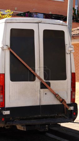             cargo van with defective rear doors, doors closed with thick ropes                   