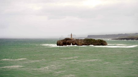           island with a lighthouse, in the coastal area of Santander Spain                     