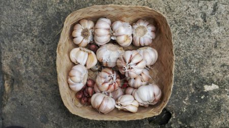Photo for Whole garlic bulbs in a container made of bamboo. - Royalty Free Image