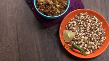 Foto de Close up view of raw and prepared sprouted soy with peppers and lemon, healthy food concept - Imagen libre de derechos