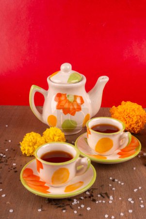 Photo for Ceramic cups with kettle on wooden and red colored background - Royalty Free Image