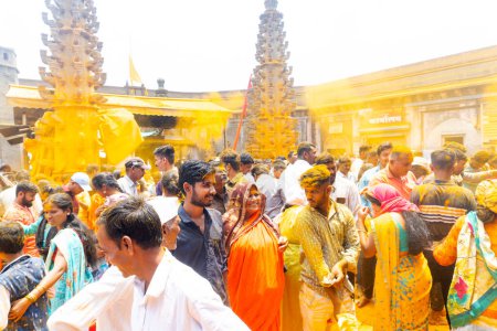 Téléchargez les photos : Jejuri, Maharashtra, Inde - 15 avril 2023 : Les dévots hindous se rassemblent pour adorer le jour de la nouvelle lune avec du curcuma, les gens jetant du curcuma au temple jejuri pendant le festival, festival Jejuri Somvati - en image libre de droit