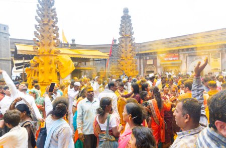 Téléchargez les photos : Jejuri, Maharashtra, Inde - 15 avril 2023 : Les dévots hindous se rassemblent pour adorer le jour de la nouvelle lune avec du curcuma, les gens jetant du curcuma au temple jejuri pendant le festival, festival Jejuri Somvati - en image libre de droit