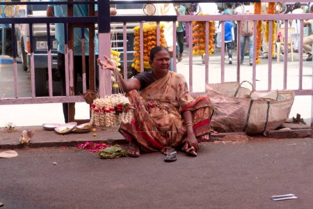 Téléchargez les photos : Femme indienne vente de fleurs sur la rue de la ville - en image libre de droit