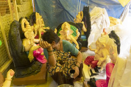 Téléchargez les photos : Femme indienne vendant des statues hindoues sur le marché local - en image libre de droit