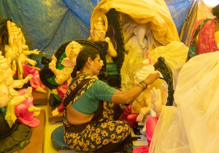 Téléchargez les photos : Femme indienne vendant des statues hindoues sur le marché local - en image libre de droit
