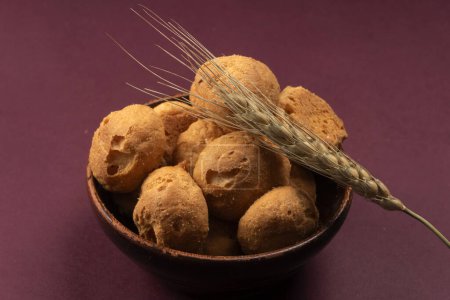Téléchargez les photos : Biscuits faits maison dans un bol avec du blé sur fond violet - en image libre de droit