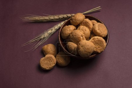 Photo for Homemade cookies in bowl with wheat on purple background - Royalty Free Image