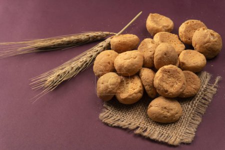 Téléchargez les photos : Biscuits faits maison avec du blé et un sac sur fond violet - en image libre de droit