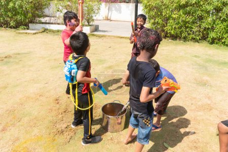 Foto de Pune Maharashtra, India - 18 de marzo de 2022: Niños indios jugando con pintura colorida durante el festival Holi. - Imagen libre de derechos