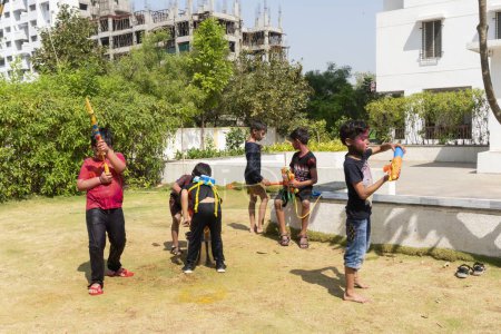 Foto de Pune Maharashtra, India - 18 de marzo de 2022: Niños indios jugando con pintura colorida durante el festival Holi. - Imagen libre de derechos