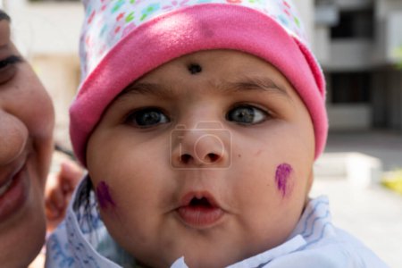 Foto de Pune, Maharashtra, India - 18 de marzo de 2022: Niño indio con la pintura de color en la cara, festival holi - Imagen libre de derechos