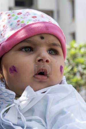 Téléchargez les photos : Pune, Maharashtra, Inde - 18 Mars, 2022 : Enfant indien avec la peinture de couleur sur le visage, holi festival - en image libre de droit