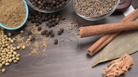 Foto de Especias indias y hierbas sobre fondo de madera. Comida e ingredientes de cocina - Imagen libre de derechos