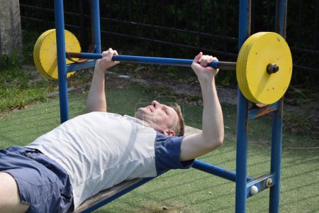 Photo for A dedicated young athlete puts in the hard work, vigorously training on gym equipment outdoors to prepare his body. He builds strength and endurance before hitting the field or court for competition - Royalty Free Image