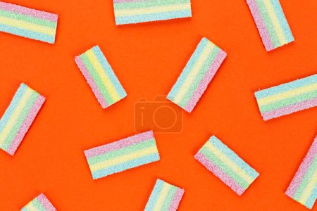 Photo for Licorice Candy. Sweet gummy sticks with different flavor, on orange background. Top view. - Royalty Free Image