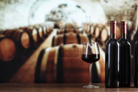 Butelka wina i kieliszki z winem na beczce w winiarni. Produkcja i degustacja wina