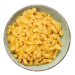 Dried macaroni cockerel scallops. Pasta in a ceramic bowl isolated on a white background. File contains clipping path.