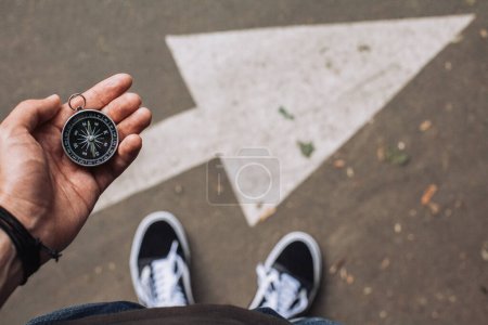 Téléchargez les photos : Hipster voyageur tenant boussole dans la main faisant le choix dans quelle direction aller - en image libre de droit
