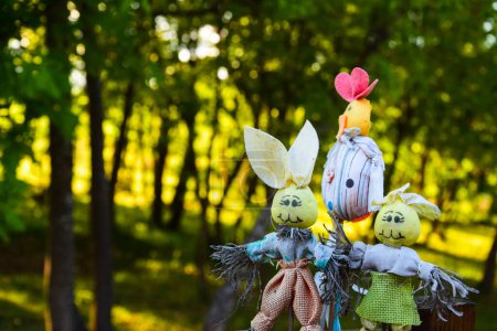 Photo for Scarecrow toys attached like decoration in the backyard with trees behind - Royalty Free Image