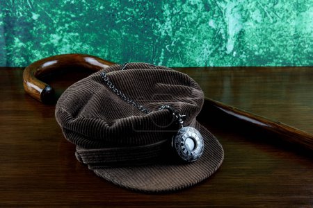 Photo for Walking stick with pocket watch and corduroy hat on a wooden surface - Royalty Free Image