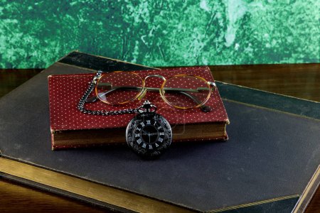 Photo for Pocket watch with old books and spectacles on a polished wooden surface - Royalty Free Image