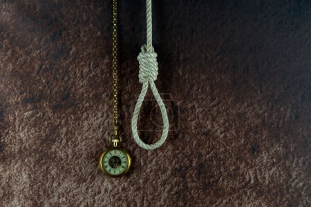 Téléchargez les photos : Hangmans noose and vintage pocket watch concept on a mottled background - en image libre de droit