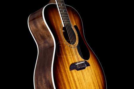 Photo for Mahogany acoustic guitar isolated upright against a black background - Royalty Free Image