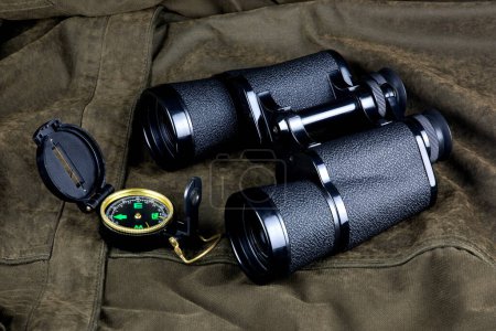 Compass and binoculars on an outdoor field coat