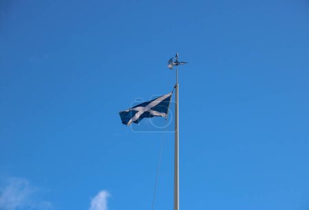 Scottish national saltire flag flying on a battleaxe flagpole at Bannockburn battlefield site in Stirling Scotland