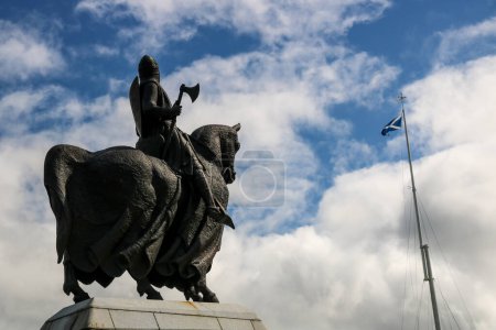 Estatua de bronce montada del rey Roberto Bruce de Escocia en el campo de batalla de Bannockburn en Escocia frente a la bandera de saltire escocesa