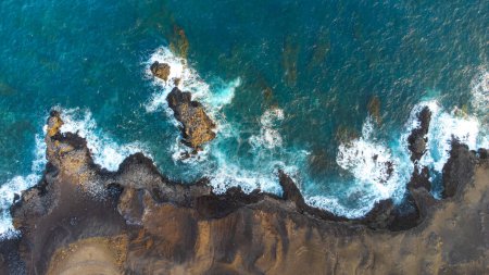 zenithal aerial drone view of waves crashing against cliffs on the island of La Palma